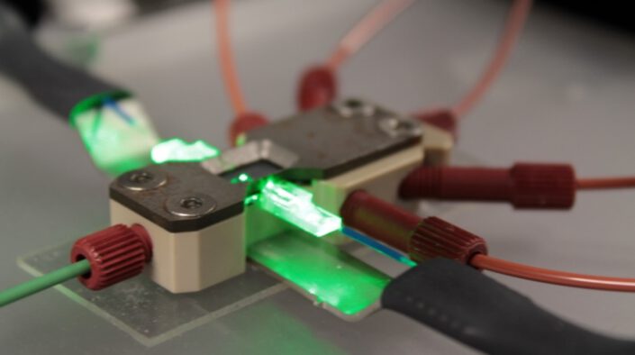 A picture of a custom packaging for a specific opto-fluidic solution for cell flow, illumination, and detection.